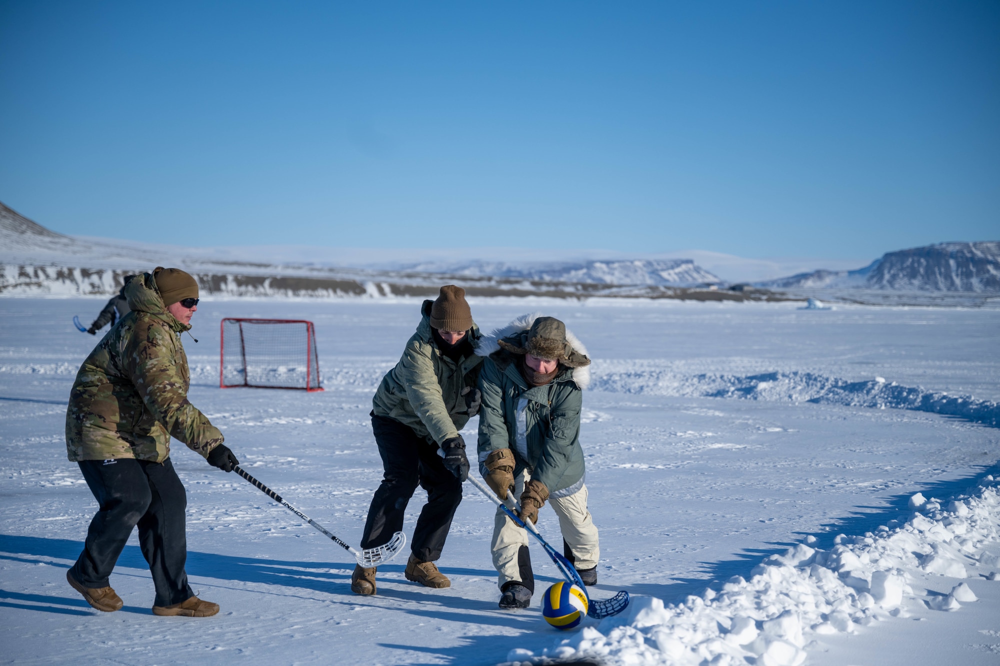 Individuals play hockey on the ice