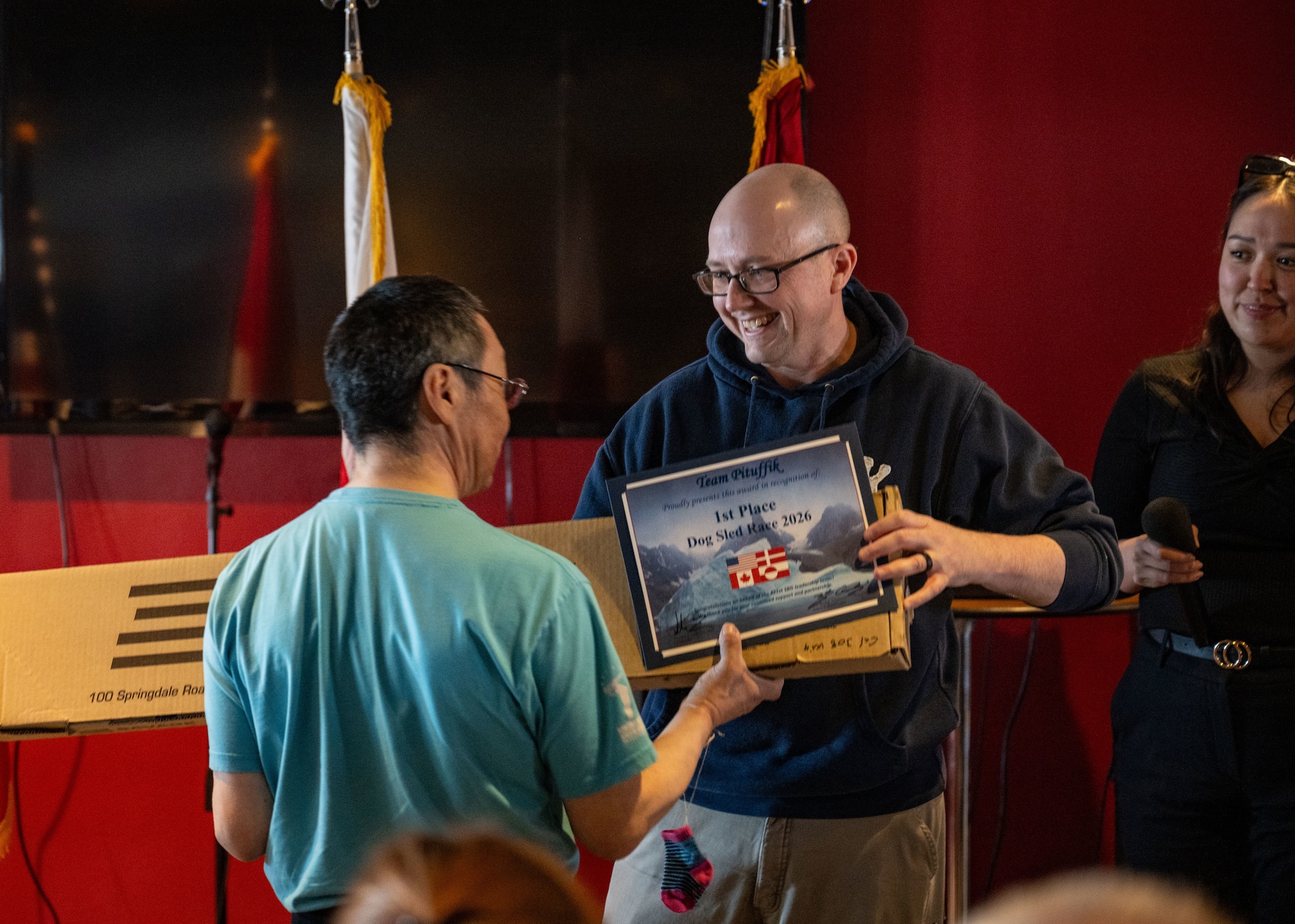 Man gives award to individual for dog sled race