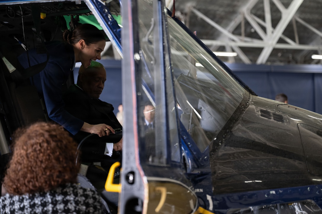 U.S. Air Force Capt. Dena McFadden, explains UH-1N Huey flight controls to honorary commander nominees prior to the 2026 Honorary Commanders Induction Ceremony.
