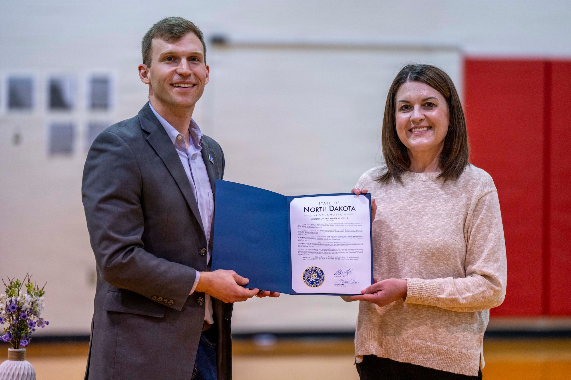 Levi Bachmeier, superintendent of public instruction for the state of North Dakota and Mary Christy, field representative for the Governor of North Dakota, present Nathan Twining Elementary and Middle School with a proclamation declaring April as Month of the Military Child at Grand Forks Air Force Base, North Dakota, April 7, 2026.