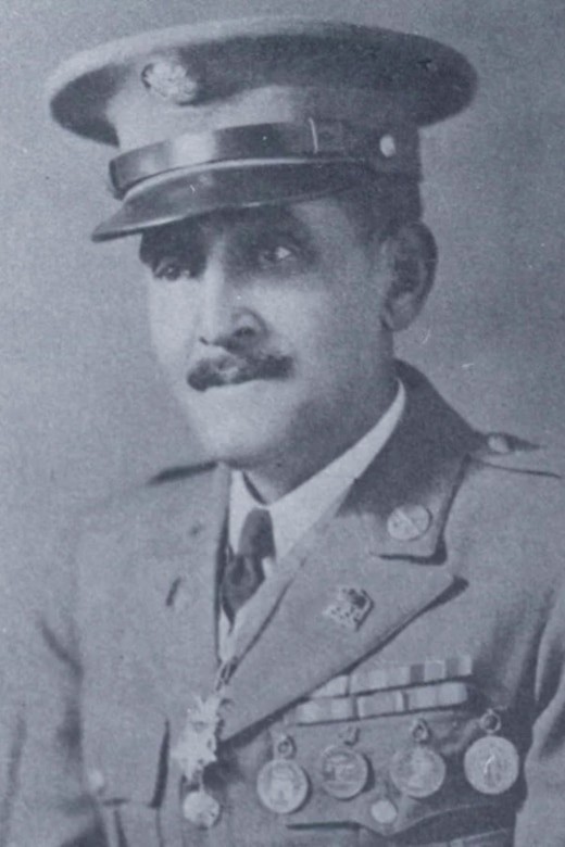 A black and white photo of a man posing for a portrait in his military dress uniform.