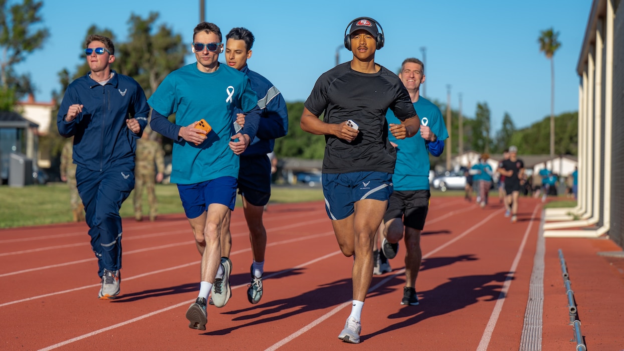 Airmen in a group run on an outdoor track