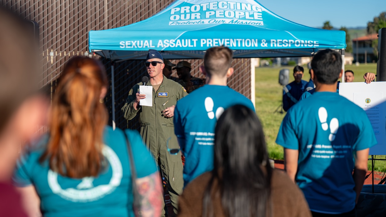 A view from the audience of a commander speaking to Airmen