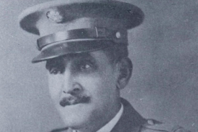 A black and white photo of a man posing for a portrait in his military dress uniform.