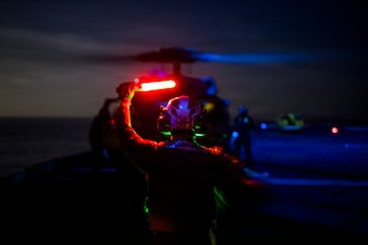 U.S. Navy Aviation Machinist’s Mate Airman Apprentice Colin Taylor, signals to a MH-60S Seahawk, assigned to Helicopter Sea Combat Squadron (HSC) 8, on the flight deck of the Nimitz-class aircraft carrier USS Theodore Roosevelt (CVN 71), April 4, 2026.