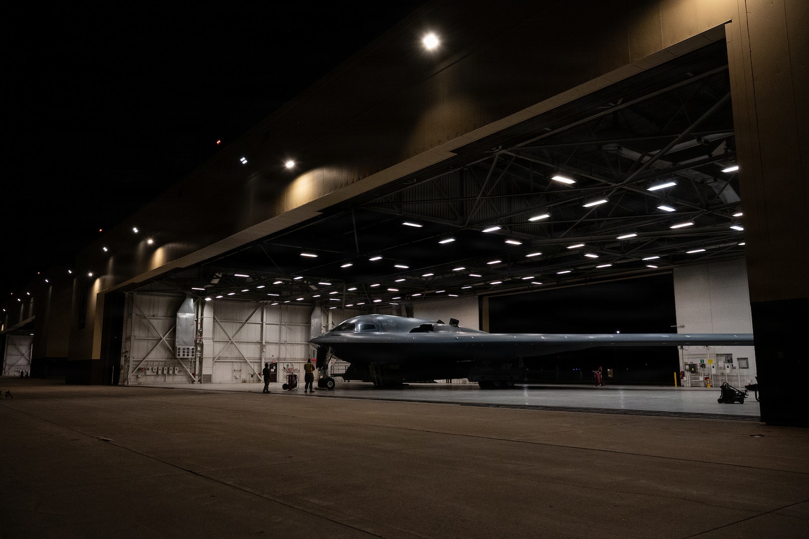 A wing-shaped aircraft sits inside a hangar.