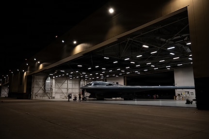 A wing-shaped aircraft sits inside a hangar.