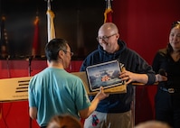Man gives award to individual for dog sled race