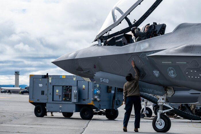 U.S. Air Force Capt. John Bove, 95th Fighter Squadron pilot, and a U.S. Air Force Airman assigned to the 95th Fighter Generation Squadron, perform pre-flight checks on a F-35A Lightning II during Red Flag-Alaska 25-3 at Eielson Air Force Base, Alaska, July 24, 2025. In addition to aircrew, RF-A provides training for deployed maintenance and support personnel to sustain large-force deployed air operations. (U.S. Air Force photo by Senior Airman Alexzandra Gracey)