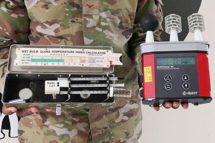 two wet bulb globe temperature meters are held side by side. the one on the left is an older model with mercury thermometers while the newer design on the right features sensors
