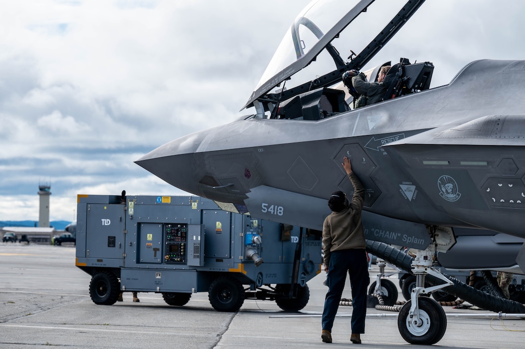 U.S. Air Force Capt. John Bove, 95th Fighter Squadron pilot, and a U.S. Air Force Airman assigned to the 95th Fighter Generation Squadron, perform pre-flight checks on a F-35A Lightning II during Red Flag-Alaska 25-3 at Eielson Air Force Base, Alaska, July 24, 2025. In addition to aircrew, RF-A provides training for deployed maintenance and support personnel to sustain large-force deployed air operations. (U.S. Air Force photo by Senior Airman Alexzandra Gracey)