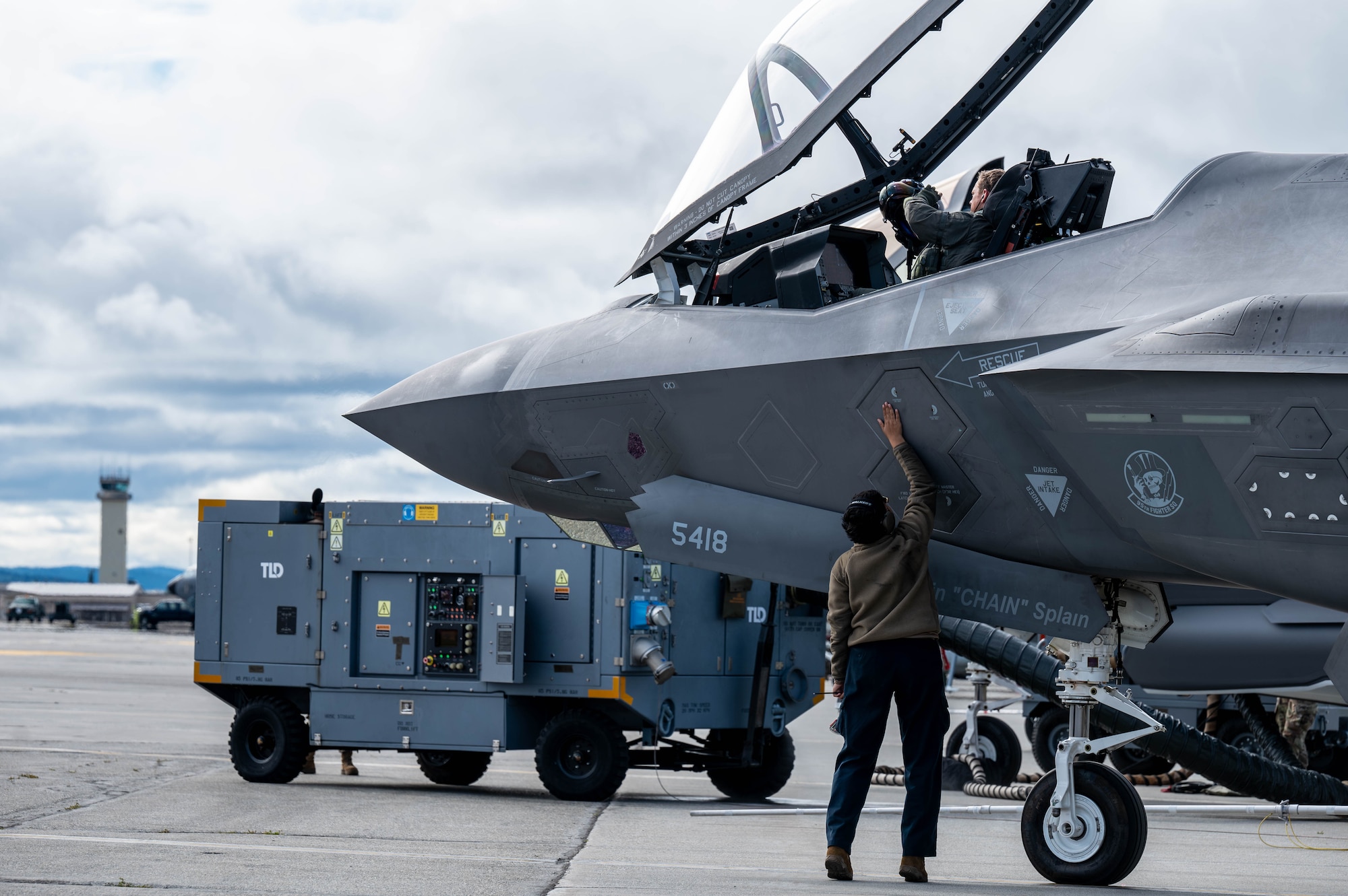 U.S. Air Force Capt. John Bove, 95th Fighter Squadron pilot, and a U.S. Air Force Airman assigned to the 95th Fighter Generation Squadron, perform pre-flight checks on a F-35A Lightning II during Red Flag-Alaska 25-3 at Eielson Air Force Base, Alaska, July 24, 2025. In addition to aircrew, RF-A provides training for deployed maintenance and support personnel to sustain large-force deployed air operations. (U.S. Air Force photo by Senior Airman Alexzandra Gracey)