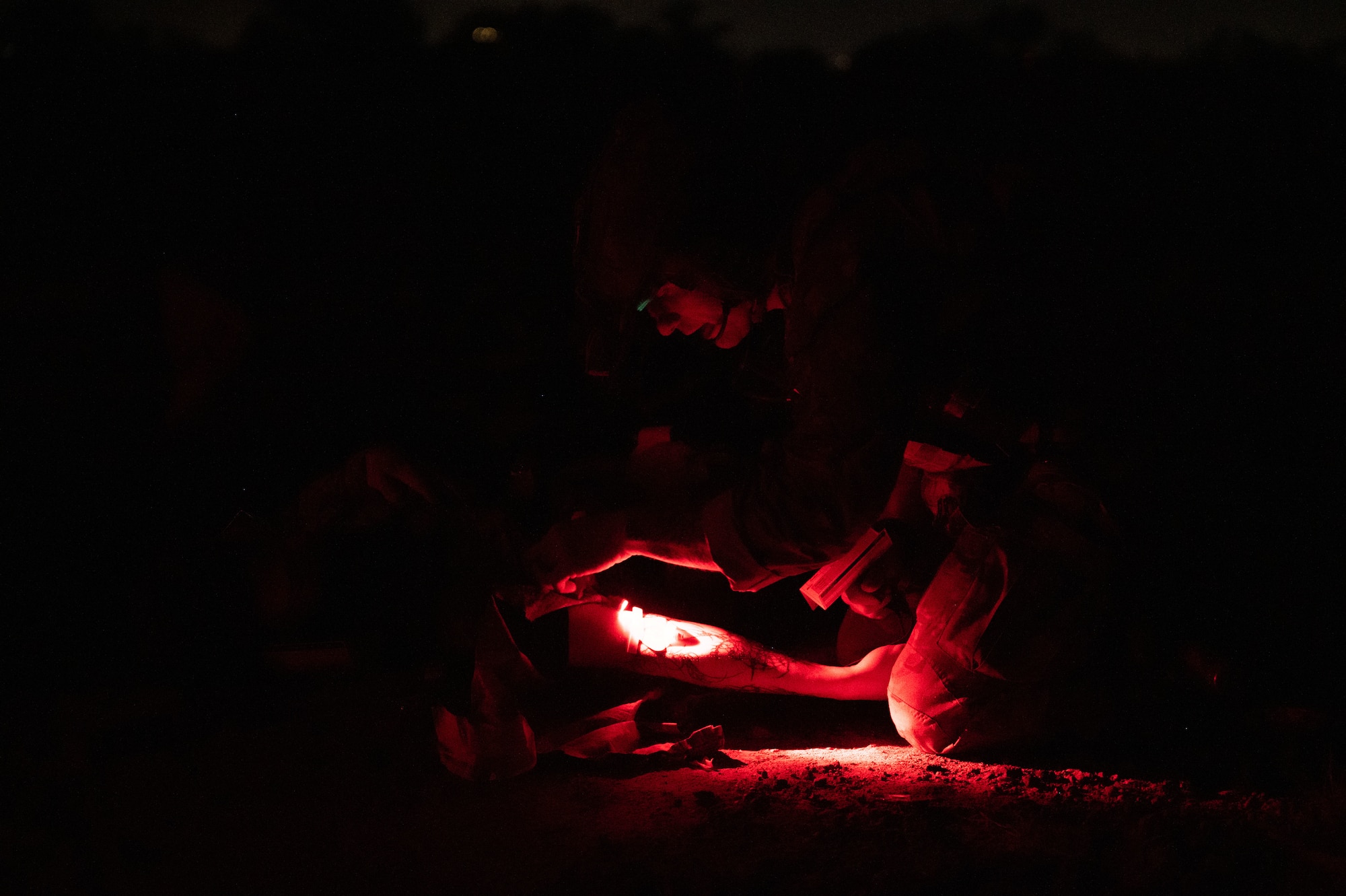 A U.S. Air Force Pararescueman assigned to the 68th Rescue Squadron provides medical care to a simulated casualty during an exercise at Davis-Monthan Air Force Base, Arizona, April 3, 2026. Airmen rescued casualties from a simulated crash site while engaging opposing forces during the training scenario. (U.S. Air Force photo by Airman 1st Class Jaden Kidd)