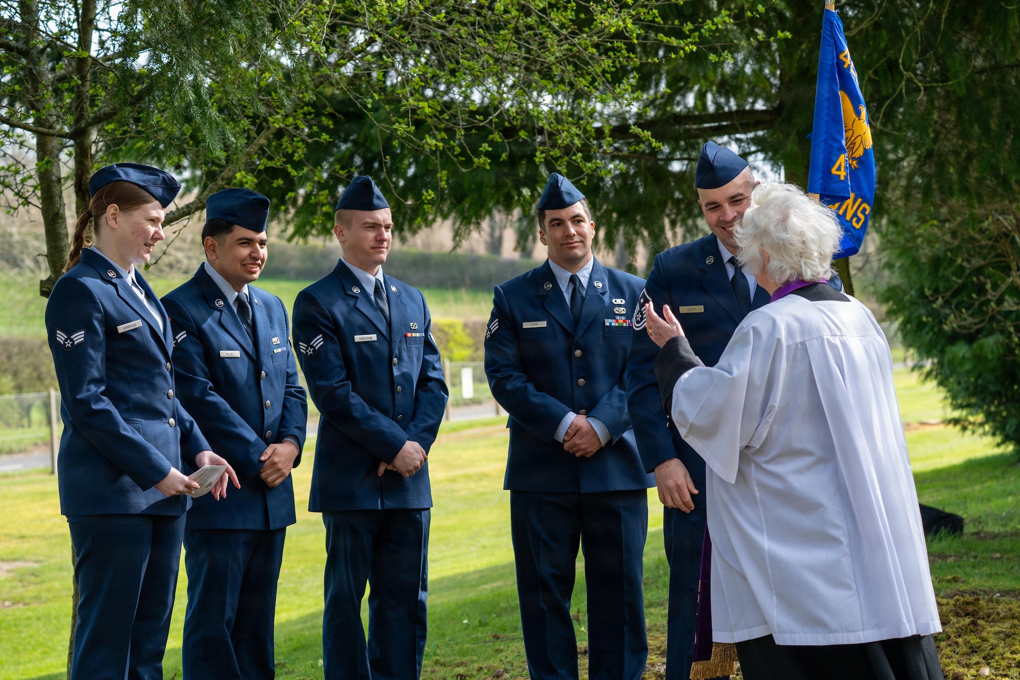 A clergy member speaks with Airmen before a memorial service