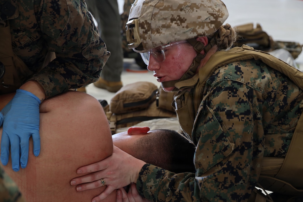 U.S Navy HM2 Riley Miller, an Aerospace Medical Technician and Field Medical Technician, with Marine Aircraft Group 24, 1st Marine Aircraft Wing, Assesses a casualty during a live action casualty simulation at Marine Corps Air Station Kaneohe Bay, Hawaii, January 09, 2026. Routine mass casualty drills provide training to maintain tactical readiness and medical proficiency. (U.S. Marine Corps photo by Staff Sgt. Heather Atherton)