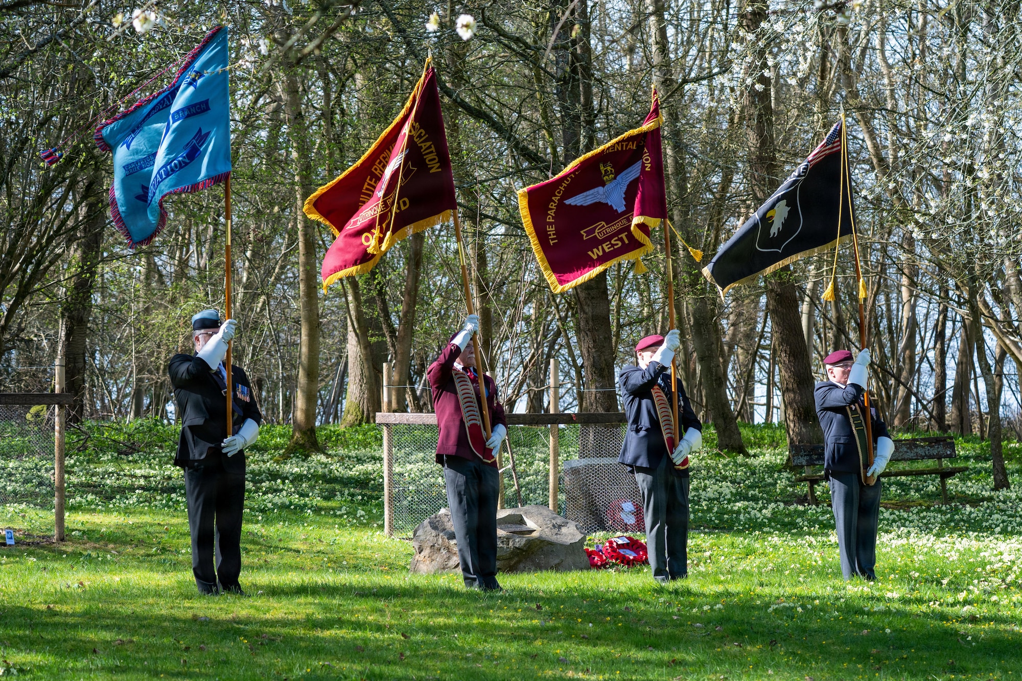 Members of the West Berkshire and Oxford Parachute Regimental Association raise their flags during a memorial service