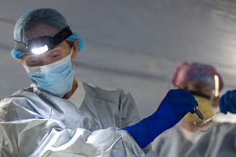 U.S. Navy Cmdr. Laura Fluke, left, a surgical oncologist with 2nd Medical Battalion, 2nd Marine Logistics Group, hands medical equipment to Petty Officer 2nd Class Hailey Dowd, a surgical technician with 2nd Medical Battalion, while providing aid to a simulated casualty as part of a simulated mass casualty event during a certification exercise at Marine Corps Base Camp Lejeune, North Carolina, March 30, 2026. 2nd Medical Battalion conducted the CERTEX to ensure Marines and Sailors are maintaining the highest standard of readiness and medical capabilities, preparing them for future potential missions. (U.S. Marine Corps photo by Lance Cpl. Isabella Ramos)