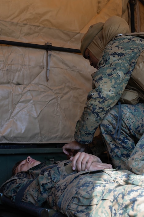 U.S. Navy Hospital Corpsman 3rd Class Sabrina Joseph, left, a corpsman with Combat Logistics Company 36, Combat Logistics Regiment 35, 3rd Marine Logistics Group, and Virginia native, performs simulated medical care on U.S. Marine Corps Pfc. Logan Roderick, a transmissions system operator with CLC-36, CLR-35, 3rd MLG, and a Texas native, during exercise Northern Dragon 26 at Japan Ground Self-Defense Force Camp Nihonbara, Okayama, Japan, March 17, 2026. CLC-36 holds exercise Northern Dragon yearly to enhance and maintain the unit’s logistics capabilities, combat marksmanship proficiency, and medical preparedness in austere terrain and weather conditions. (U.S. Marine Corps photo by Cpl. Colin Thibault)