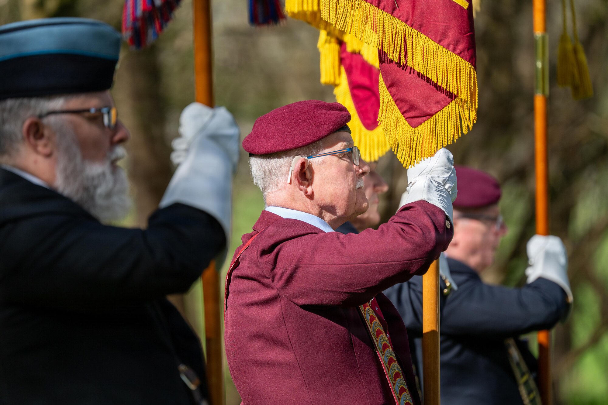 Members of the West Berkshire and Oxford Parachute Regimental Association raise their flags during a memorial service