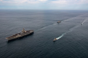 Overhead view of naval warships sailing in formation in the open sea.
