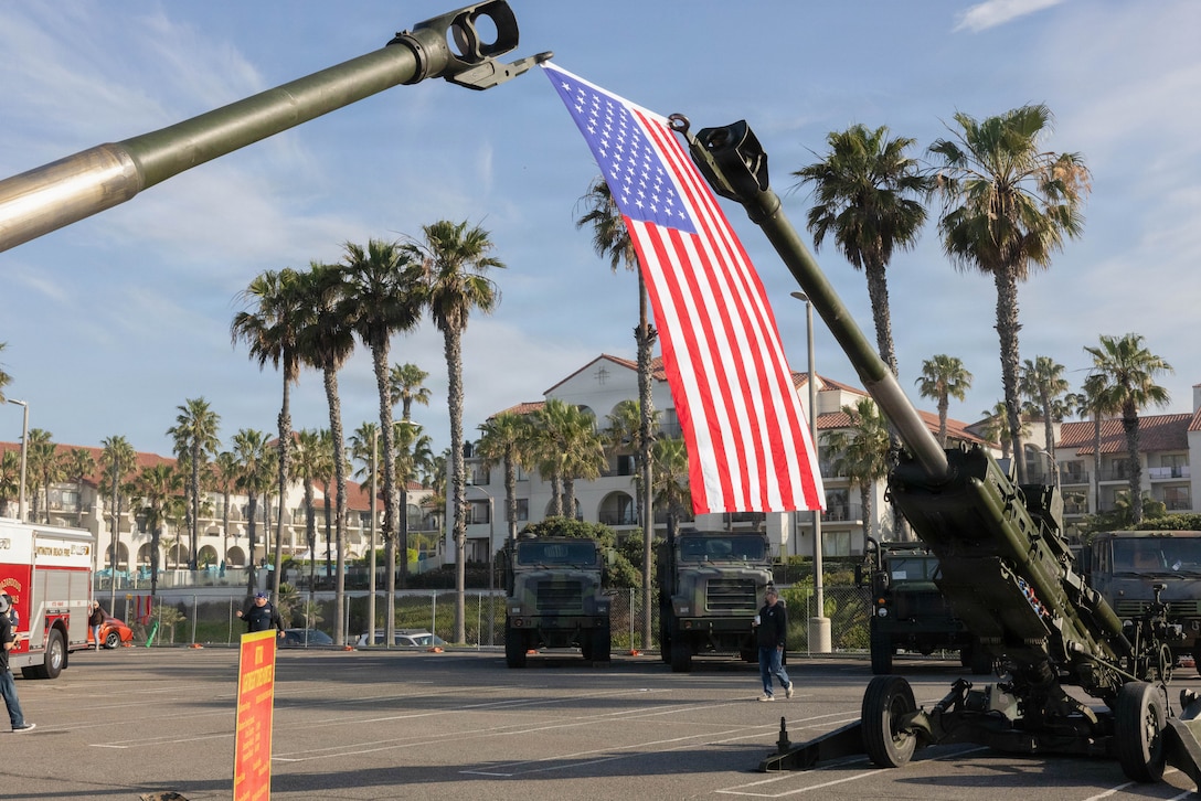 An American flag is displayed along with two M777A2 Howitzers during the Hot Rods N’ Heroes Car Show at Huntington Beach, California, March 29, 2026. The Hot Rods N’ Heroes Car Show displays Southern California’s car culture by showcasing hot rods, classic cars, vintage cars, and many more alongside law enforcement, fire, and military vehicles and assets to create a unique experience for car show attendees. (U.S. Marine Corps photo by Lance Cpl. Dylan Jameson)