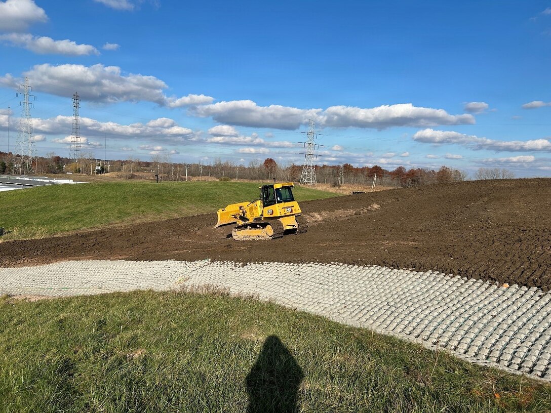 Construction equipment driving over the FUSRAP Seaway Site as the engineered cap nears completion.