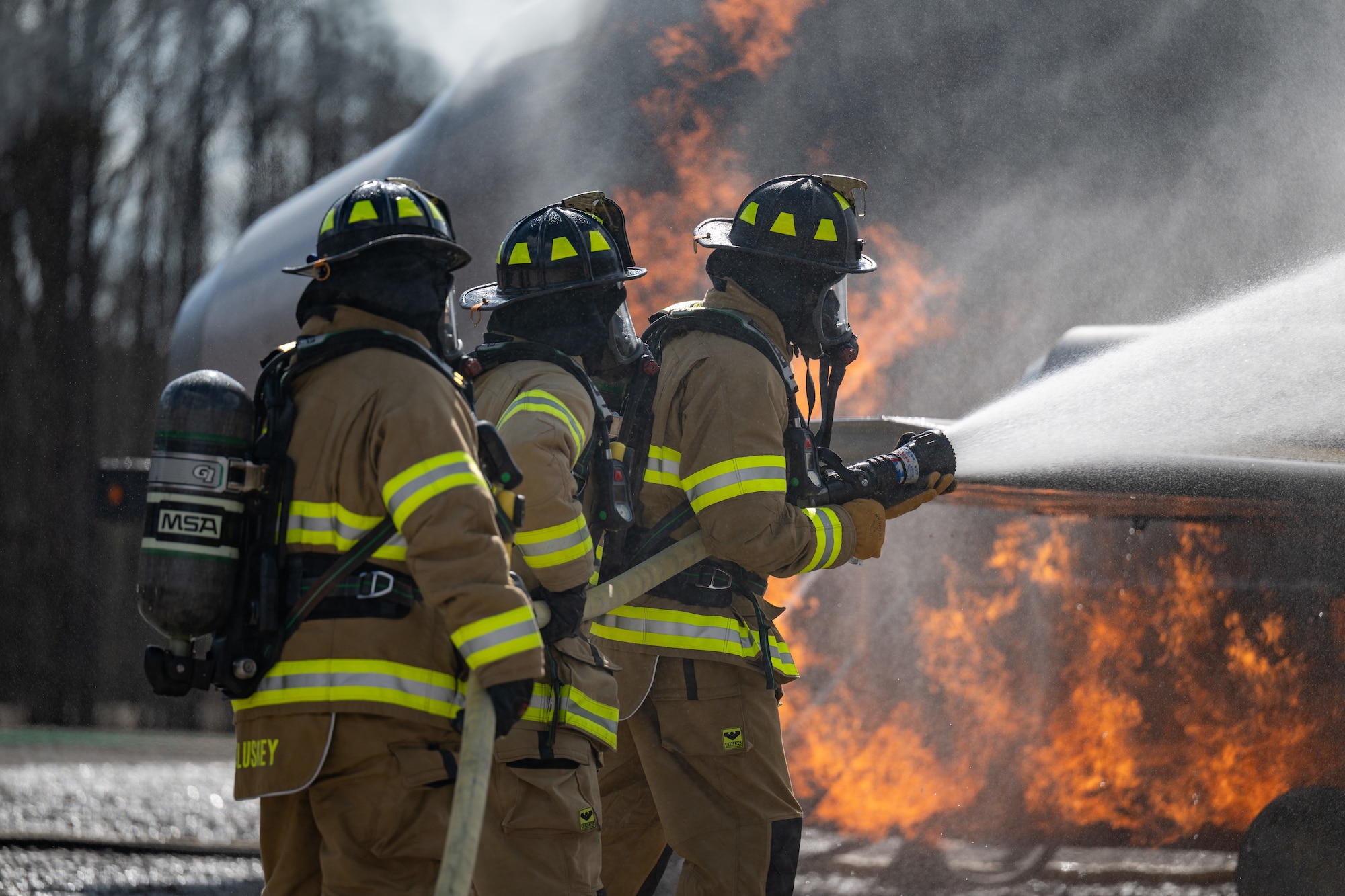Arnold Engineering Development Complex Individual Mobilization Augmentee Col. Aaron Stevenson, right, mans the firehose to extinguish fires on a simulated aircraft fuselage during live fire training March 6, 2026, at Arnold Air Force Base, Tenn. AEDC leadership once again participated in the annual training which is conducted by FES to maintain readiness in the event of an emergency and to meet National Fire Protection Association and Air Force requirements. Arnold AFB is the headquarters of AEDC. (U.S. Air Force photo by Keith Thornburgh)
