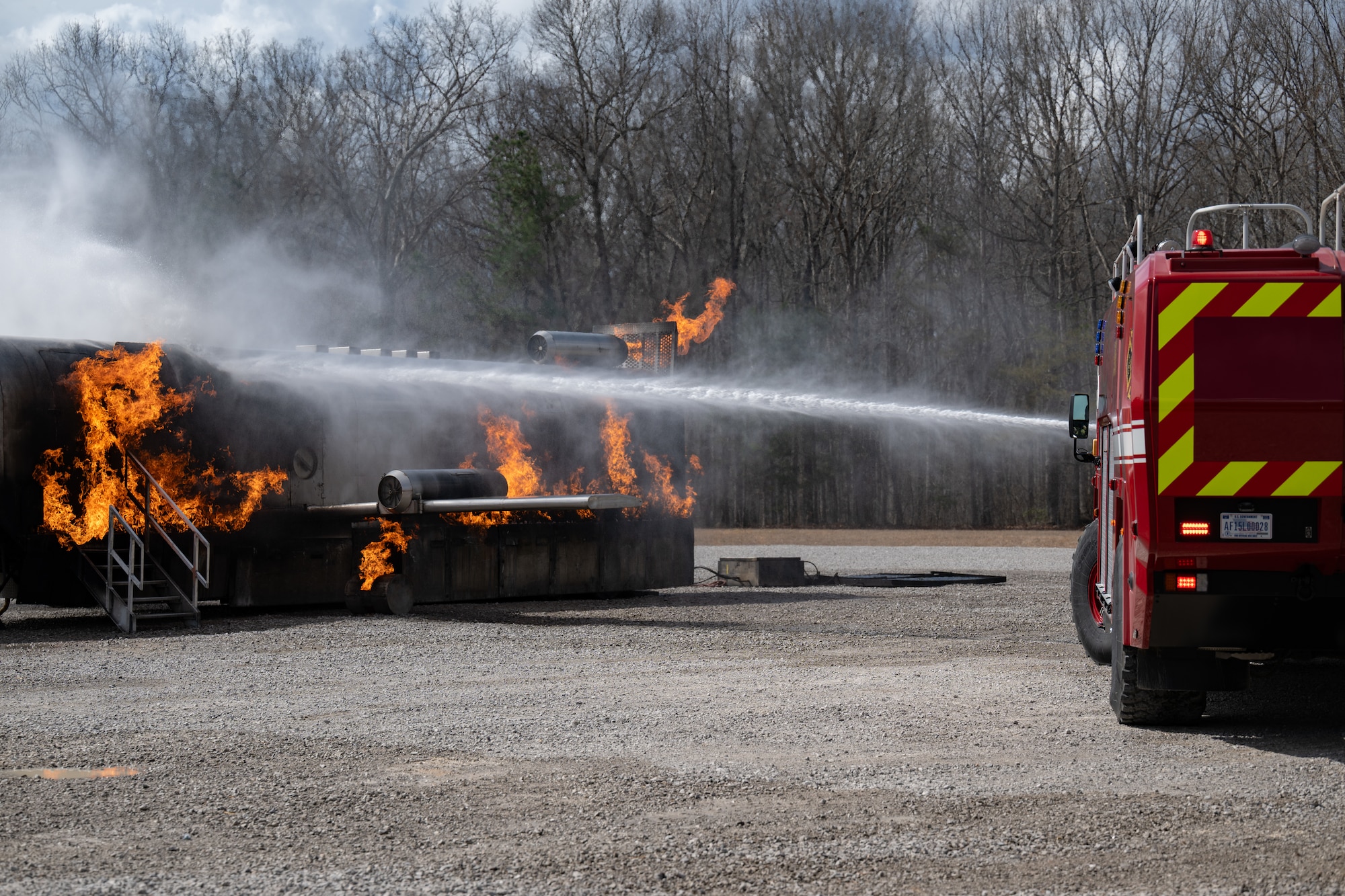 An Arnold Air Force Base Fire and Emergency Services Aircraft Rescue and Fire Fighting truck is used to douse high-pressure water on an exterior aircraft fire during fuselage live fire training March 6, 2026, at Arnold AFB, Tenn. The annual training is conducted by FES to maintain readiness in the event of an emergency and to meet National Fire Protection Association and Air Force requirements. Arnold AFB is the headquarters of AEDC. (U.S. Air Force photo by Keith Thornburgh)