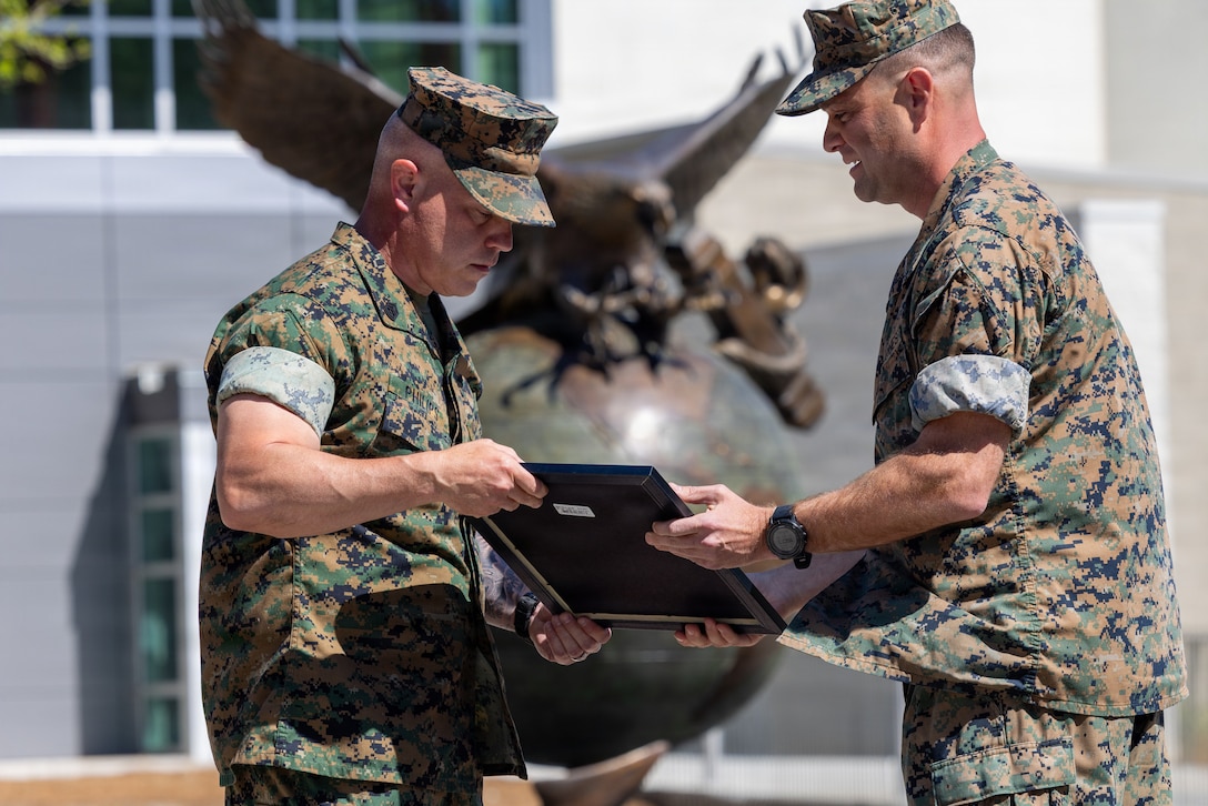 U.S. Marine Corps Lt. Col. Richard DiCarlo, right, executive officer of Deployment Processing Command Support-Reserve Support Unit East, hands a promotion warrant to Gunnery Sgt. Bobby Philips Jr., motor transport chief, 4th Light Armored Reconnaissance Battalion, 4th Marine Division during a meritorious promotion ceremony in Jacksonville, North Carolina, April 2, 2026. Philips was selected for meritorious promotion spanning across Marine Forces Reserve. (U.S. Marine Corps photo by Sgt. Alexander Lesko)