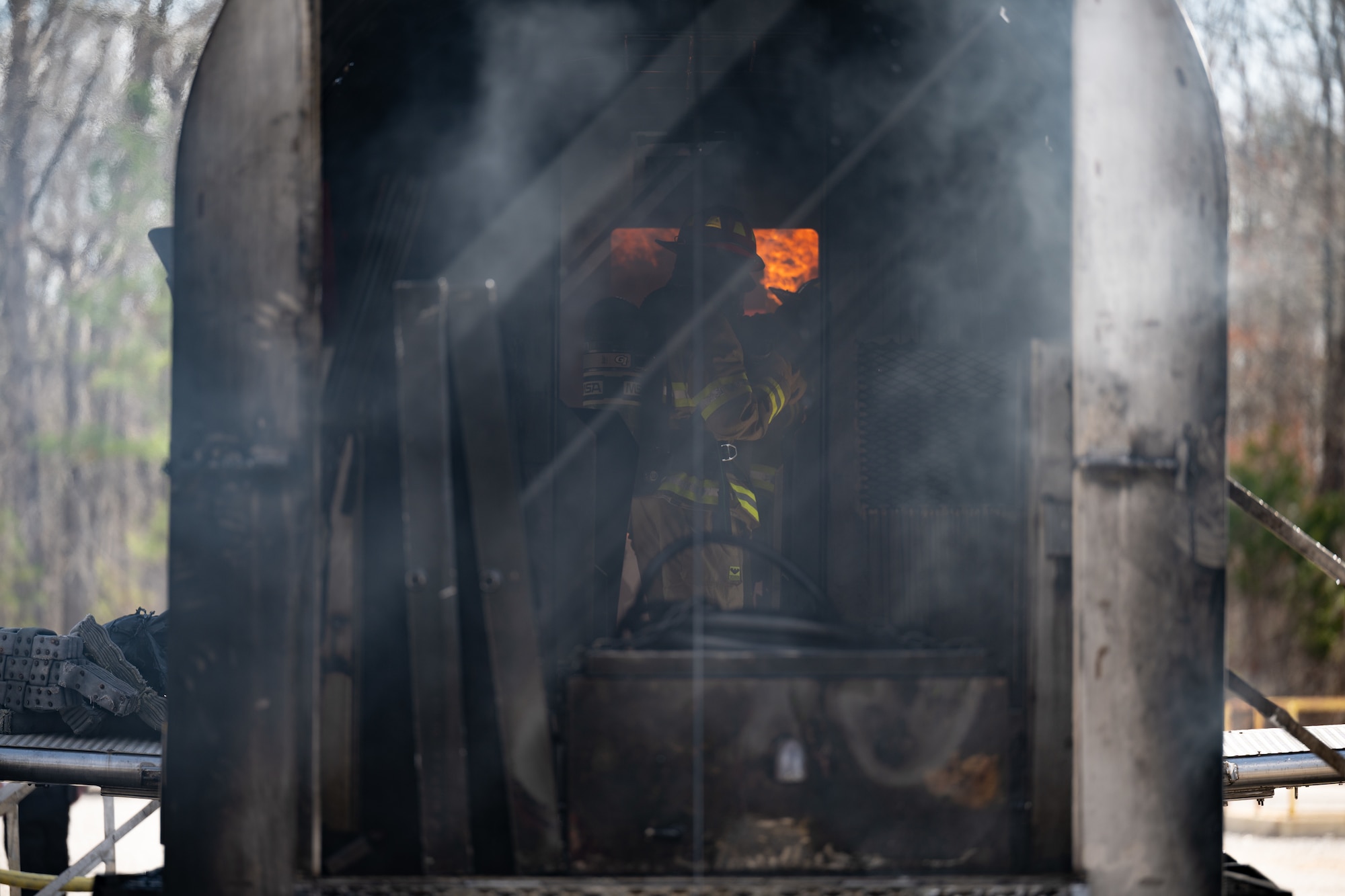 Arnold Engineering Development Complex Commander Col. Grant Mizell battles fires while working his way through a simulated aircraft fuselage during live fire training March 6, 2026, at Arnold Air Force Base, Tenn. AEDC leadership once again participated in the annual training which is conducted by FES to maintain readiness in the event of an emergency and to meet National Fire Protection Association and Air Force requirements. Arnold AFB is the headquarters of AEDC. (U.S. Air Force photo by Keith Thornburgh)