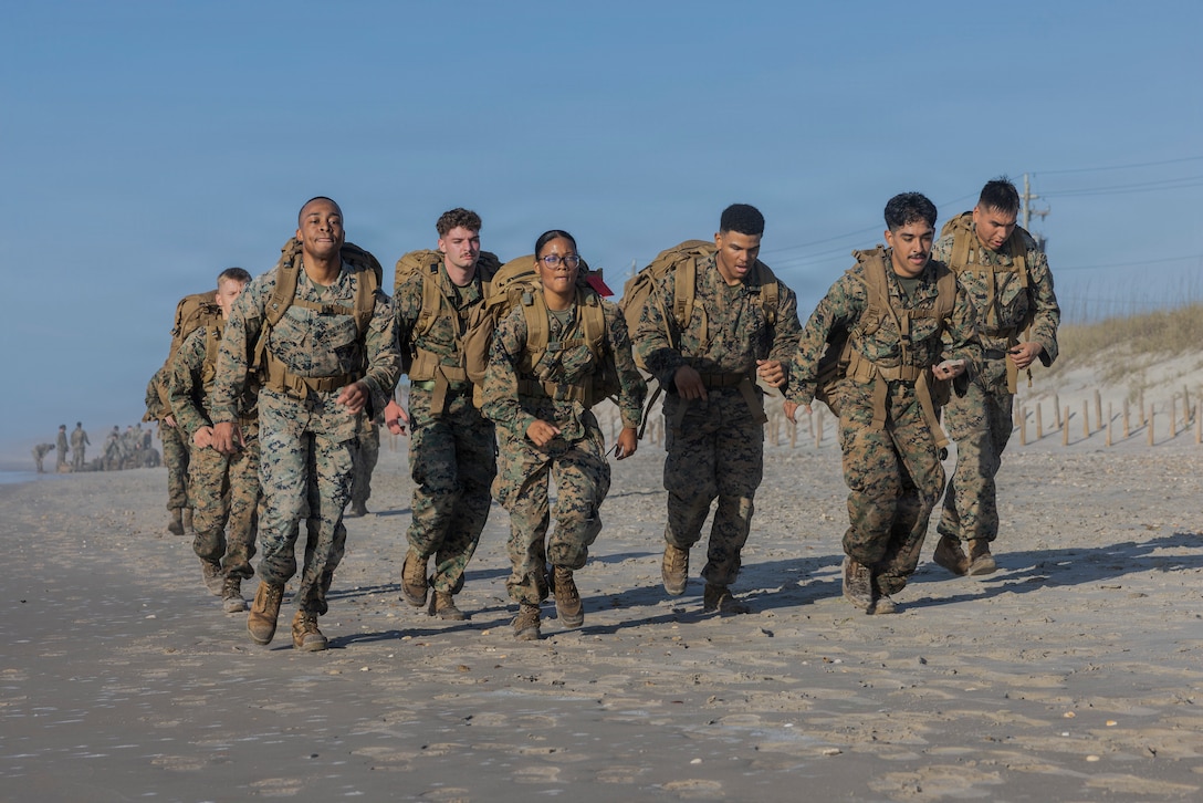 U.S. Marines with II Marine Expeditionary Force Support Battalion, run together during a
ruck-run at Onslow Beach on Marine Corps Base Camp Lejeune, North Carolina, April
2, 2026. The purpose of this training is to enhance physical readiness and unit
cohesion. (U.S. Marine Corps photo by Lance Cpl. Sabine Wilson)