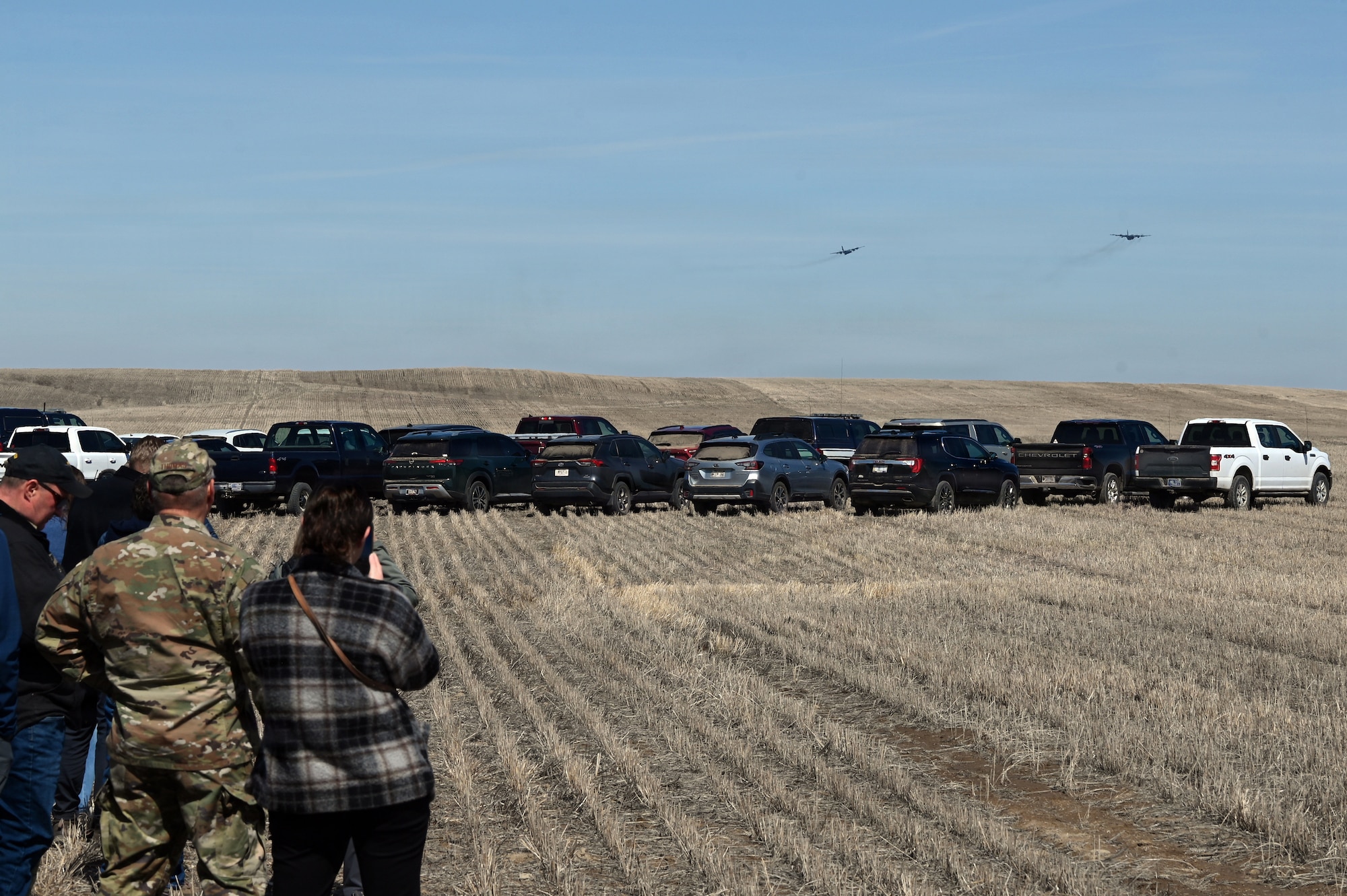 Attendees observe C-130H aircraft assigned to the 120th Airlift Wing conducting aerial delivery operations over the Vigilante Drop Zone near Power, Montana, April 6, 2026.