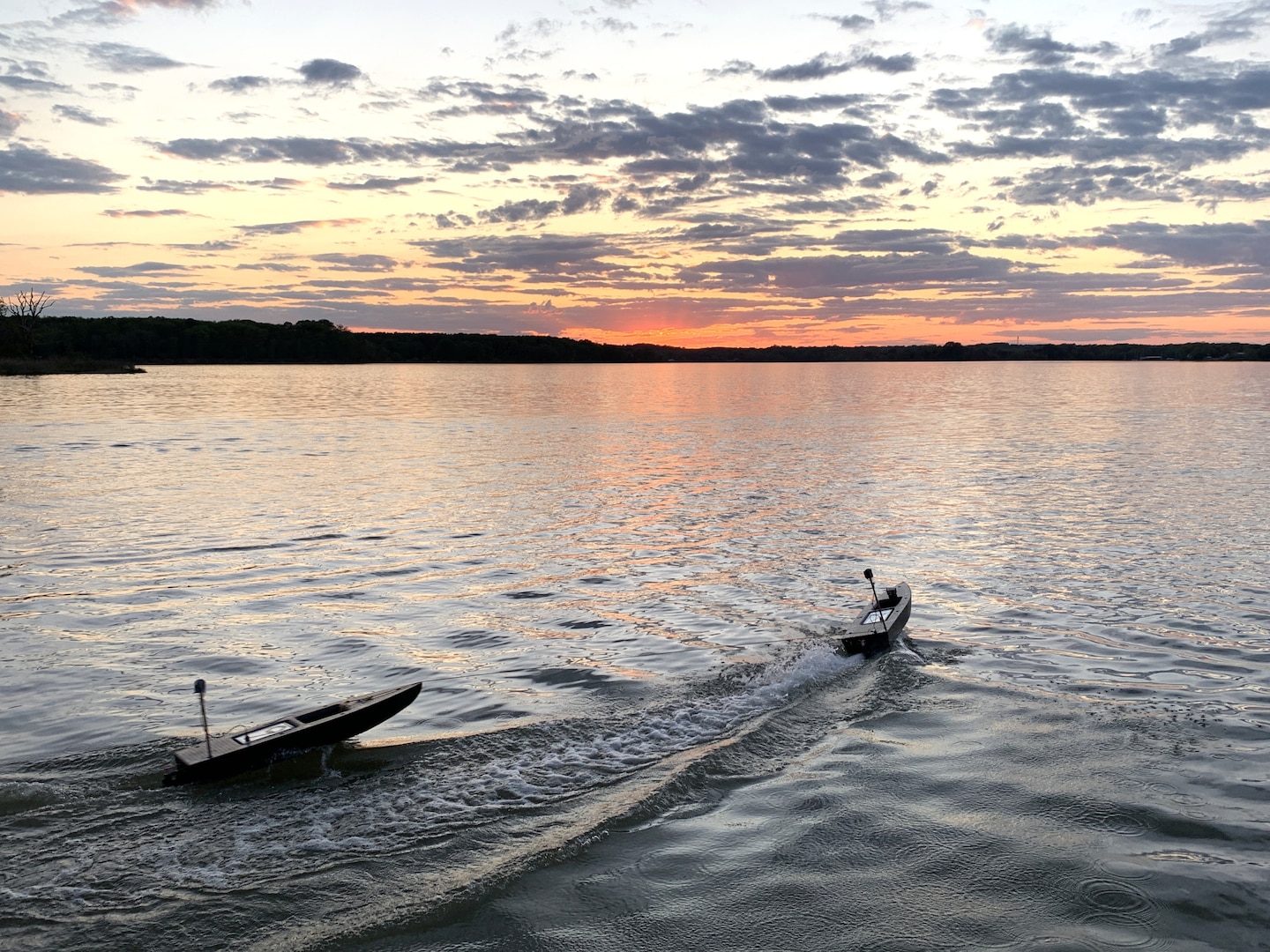 Unmanned surface vehicles (USVs) operate during a multi-domain robotics force-on-force exercise at Naval Surface Warfare Center Dahlgren Division, demonstrating continued performance during low-light and reduced-visibility conditions. The exercise evaluated the integration of autonomous systems in maritime environments across day-to-night transitions.
