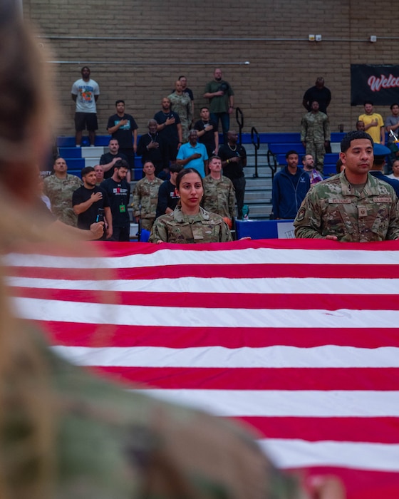 U.S. Air Force Airman Ajin Howard, 56th Force Support Squadron reenlistment extensions apprentice, holds the U.S. Flag during the national anthem, April 2, 2026, at Luke Air Force Base, Arizona.