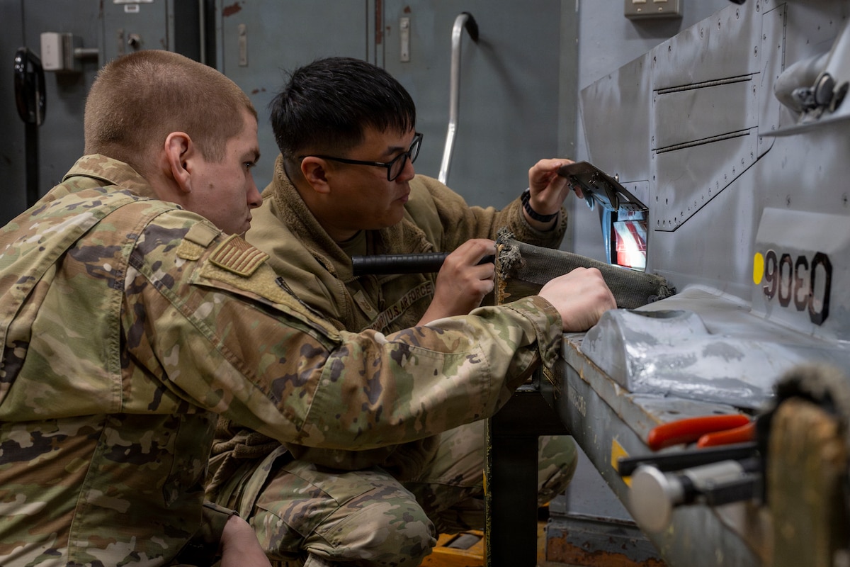 U.S. Air Force Tech. Sgt. Anferne Phachansiri, right, and Staff Sgt. Gerald Messer, 35th Maintenance Group quality assurance inspectors, examine an F-16 Fighting Falcon wing weapons pylon at Misawa Air Base, Japan, March 31, 2026.