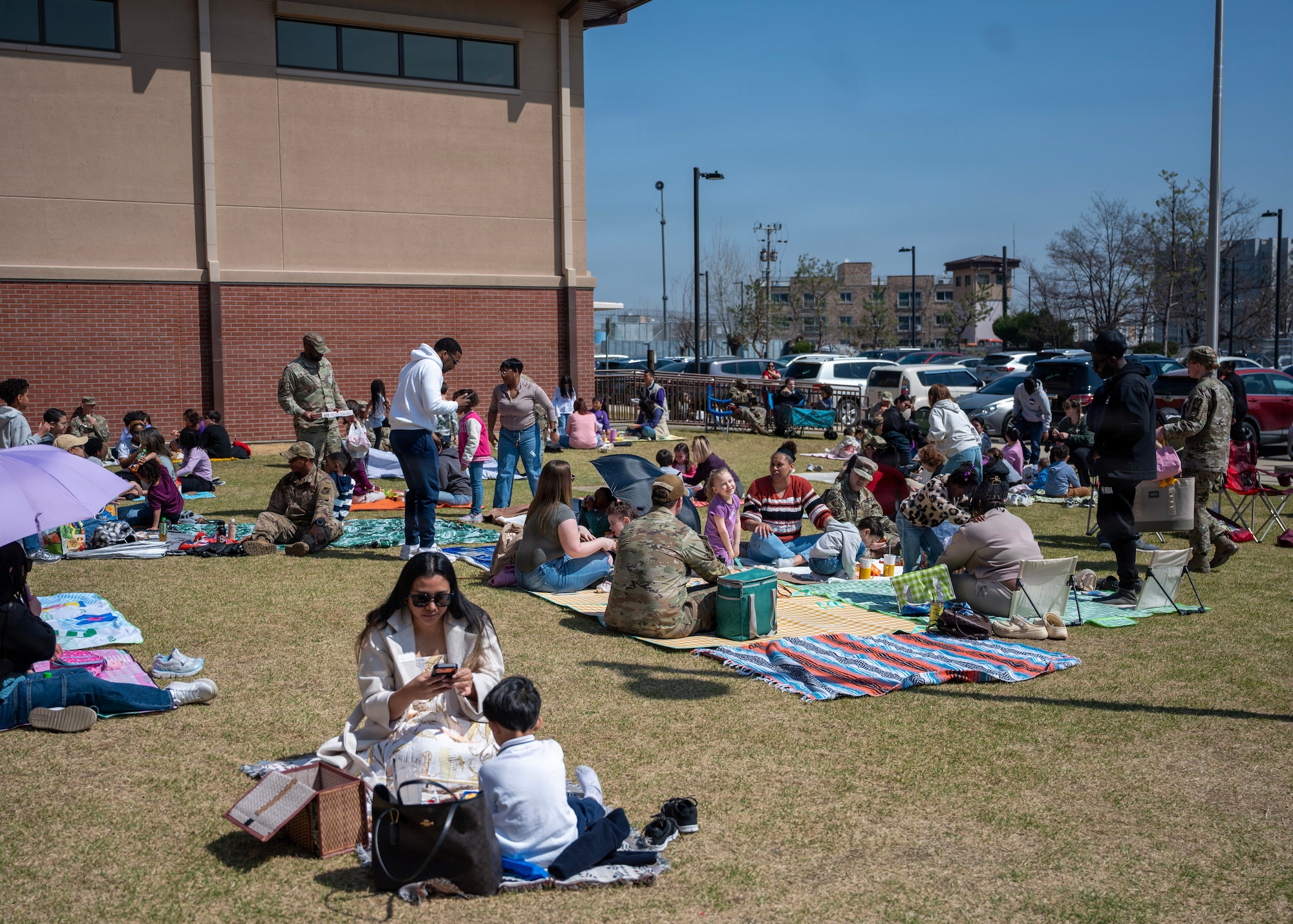 Families eat lunch during the Month of Military Child Picnic at Osan Elementary School, Osan Air Base, Republic of Korea, April 8, 2026. The annual event transformed the school grounds into a shared space where families could step into their children’s daily environment, enjoy lunch and strengthen connections between students, parents and educators. (U.S. Air Force photo by Staff Sgt. Sarah Williams)