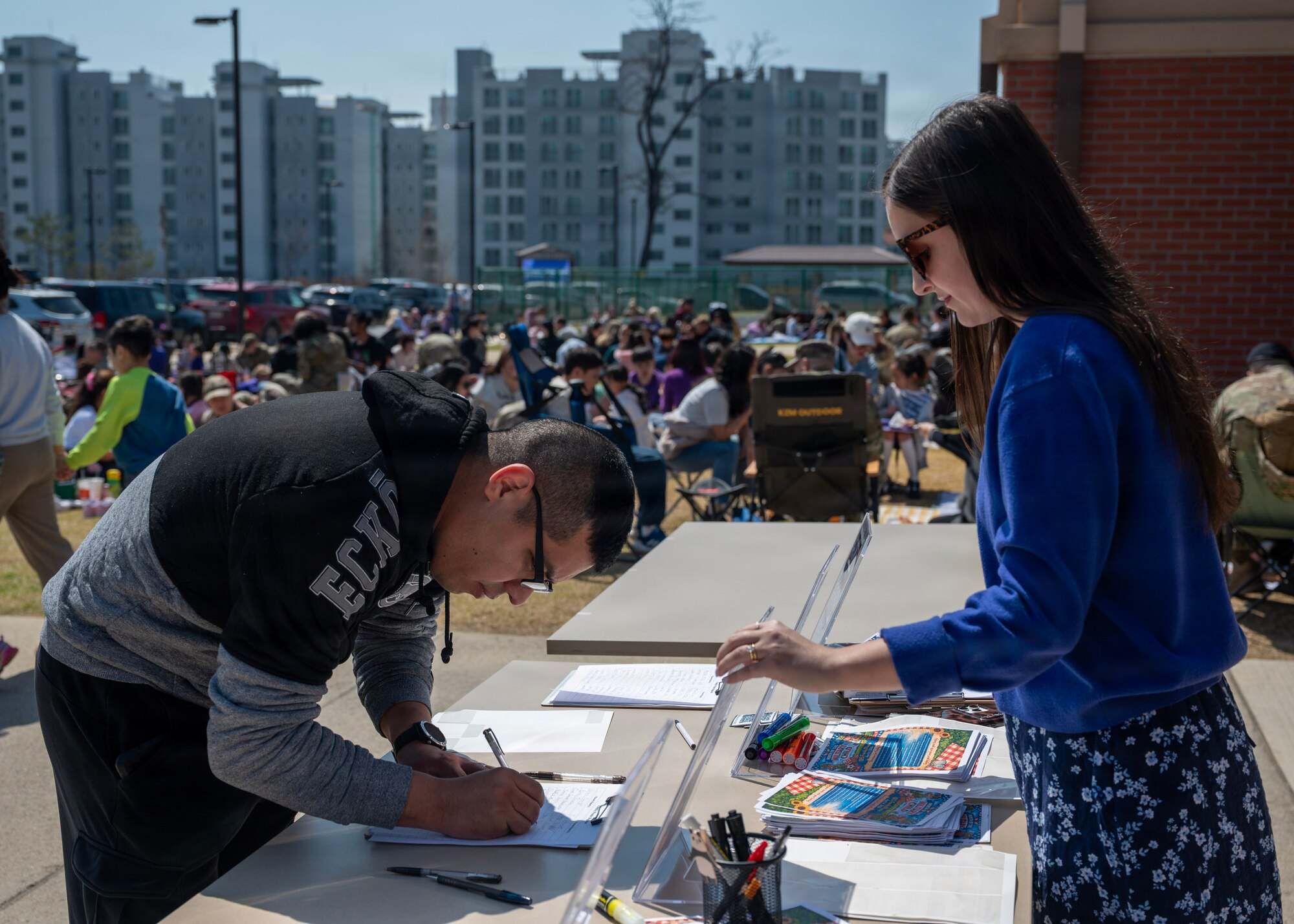 A parent signs in during the Month of Military Child Picnic at Osan Elementary School, Osan Air Base, Republic of Korea, April 8, 2026. Month of Military Child recognizes the vital role military children play in supporting service members and the mission. (U.S. Air Force photo by Staff Sgt. Sarah Williams)