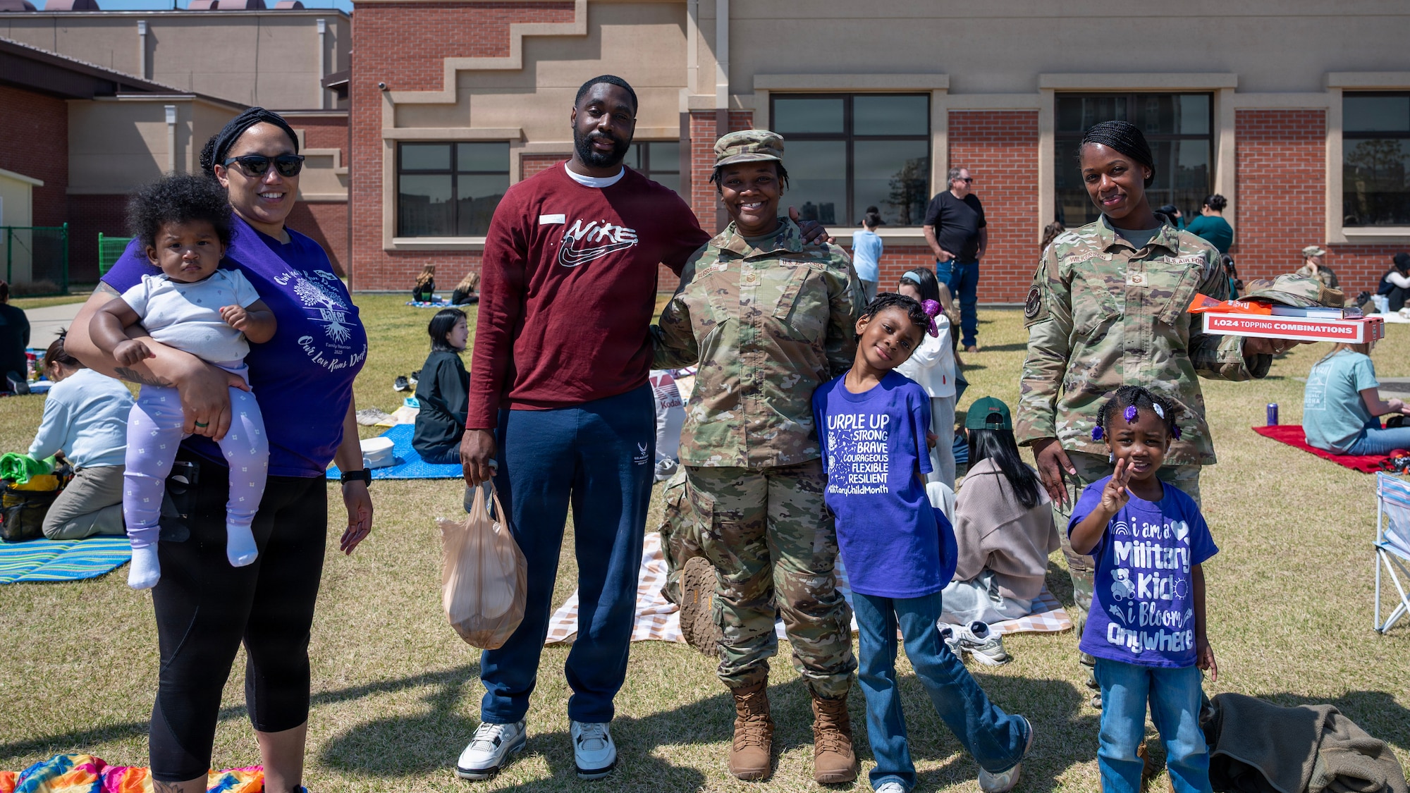 A family poses for a photo during the Month of Military Child Picnic at Osan Elementary School, Osan Air Base, Republic of Korea, April 8, 2026.  The picnic highlighted the unique experiences military children face and the strength they demonstrate through constant change. (U.S. Air Force photo by Staff Sgt. Sarah Williams)