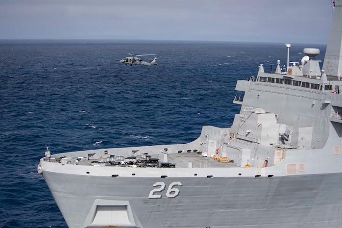 An MH-60S Sea Hawk helicopter, attached to Helicopter Sea Combat Squadron (HSC) 23 flies by amphibious transport dock ship USS John P. Murtha (LPD 26), in the Pacific Ocean, April 8, 2026.
