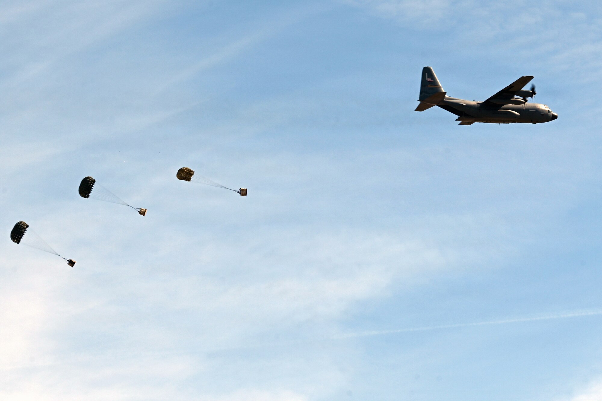 A U.S. Air Force C-130H aircraft assigned to the 120th Airlift Wing releases cargo bundles during an aerial delivery mission over the Vigilante Drop Zone near Power, Montana, April 6, 2026.