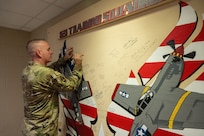 Chief Master Sergeant of the Air Force David R. Wolfe signs the Mustang Wall at the 323rd Training Squadron.
