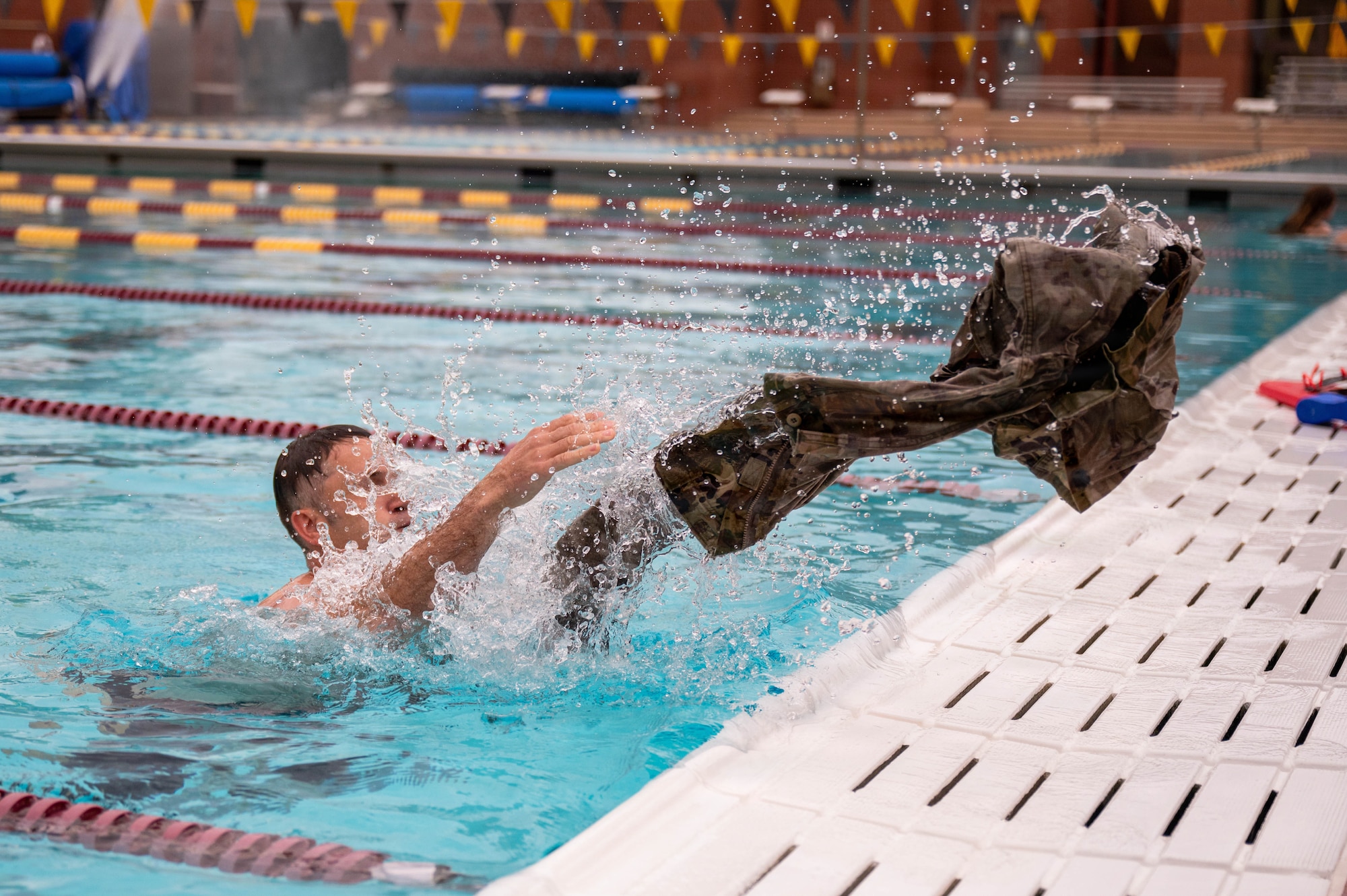 U.S. Air Force Master Sgt. Kenneth Stover, food services superintendent assigned to the 161st Air Refueling Wing, throws his uniform out of the pool during the 100-meter swim portion of the German Armed Forces Proficiency Badge assessment at Arizona State University in Tempe, Arizona, April 1, 2026. The GAFPB is a decoration of the Bundeswehr, the Armed Forces of the Federal Republic of Germany, and is one of few foreign military badges authorized to be worn by U.S. Air Force, Army, and Space Force members. (U.S. Air National Guard photo by Airman 1st Class Jacob Hreshchyshyn)