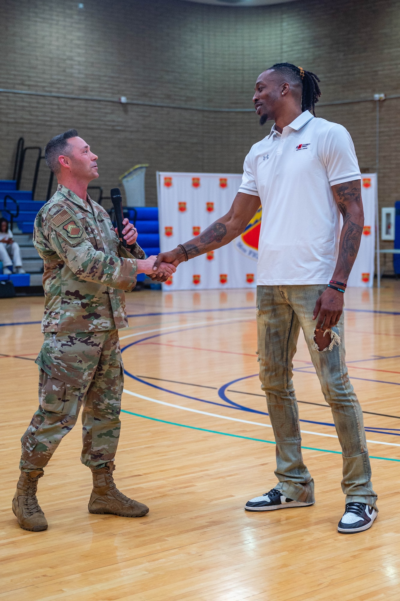 U.S. Air Force Col. Darryl Hebert (left), 56th Mission Support Group commander, greets Dwight Howard (right), former NBA player, April 2, 2026, at Luke Air Force Base, Arizona.