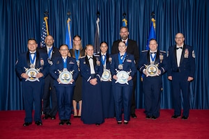 Uniformed and civilian Airmen pose for a group photo.