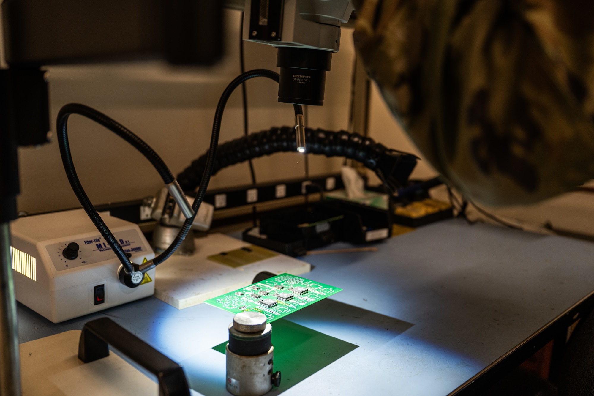 U.S. Air Force Staff Sgt. James Dagger, 7th Maintenance Group Air Force Repair Enhancement Program technician, examines a circuit card under a microscope at Dyess Air Force Base, Texas, March 23, 2026. AFREP technicians undergo extensive training to achieve miniature and microminiature soldering certification, enabling precise repairs on critical electronic components. (U.S. Air Force photo by Airman 1st Class Caleb Schellenberg)