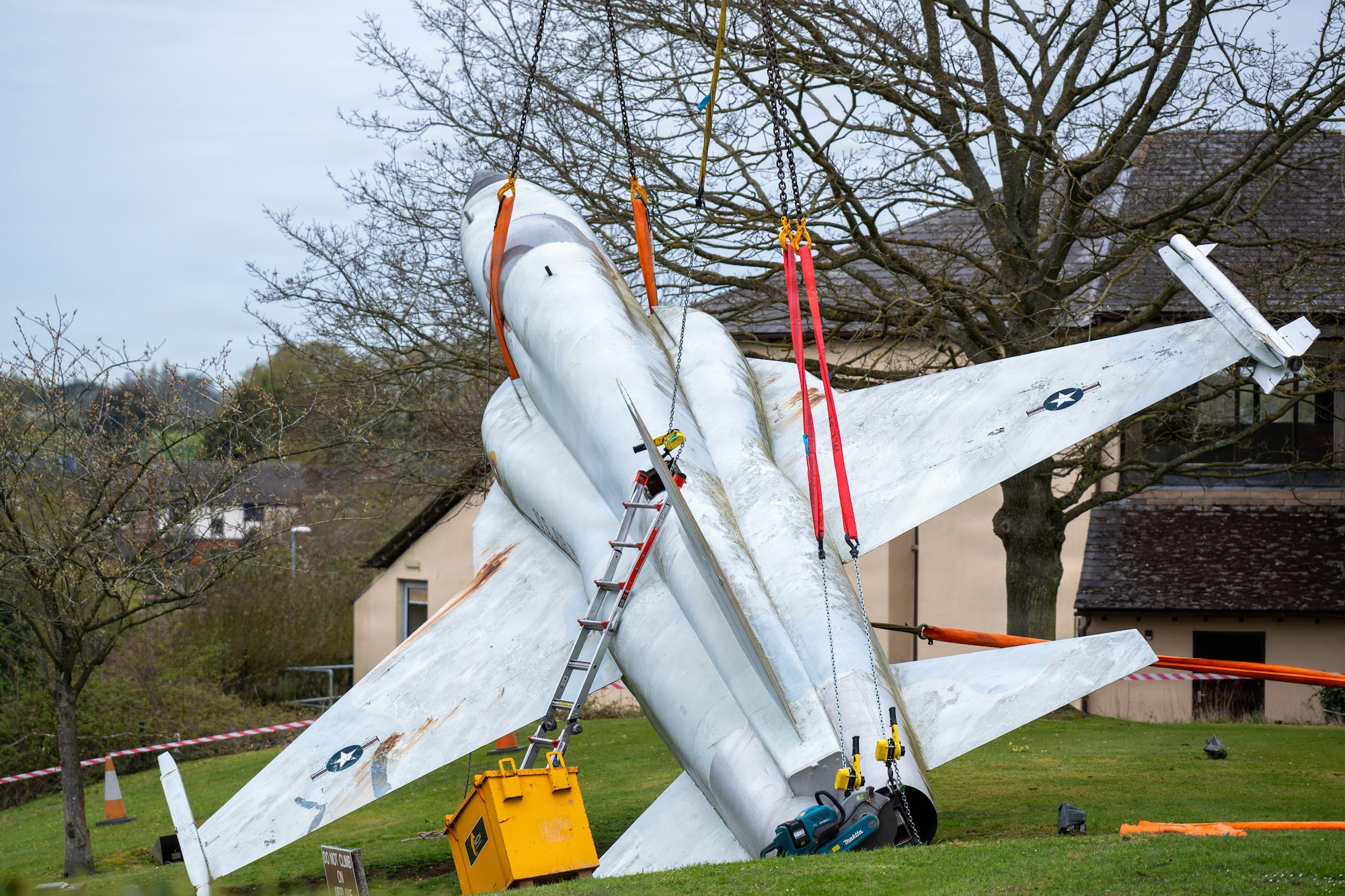 A U.S. Air Force F-5E Tiger II replica is lifted by crane during removal operations at RAF Alconbury,