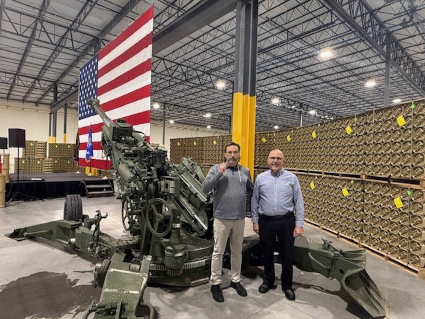 Two men stand near the American flag