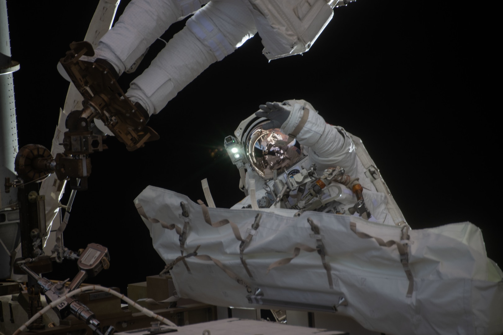 An astronaut waves during a spacewalk