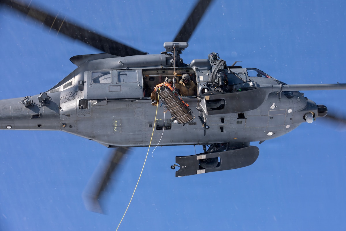 U.S. Air Force HH-60W Jolly Green II helicopter aircrew assigned to the 210th Rescue Squadron, 176th Wing, Alaska Air National Guard, hoist a simulated downed pilot during a full mission profile training exercise at Malemute Drop Zone, Joint Base Elmendorf-Richardson, Alaska, March 31, 2026. The training included search and rescue, high-altitude parachute drops, emergency medical response, personnel recovery and rescue hoist. (Alaska National Guard photo by Alejandro Peña)