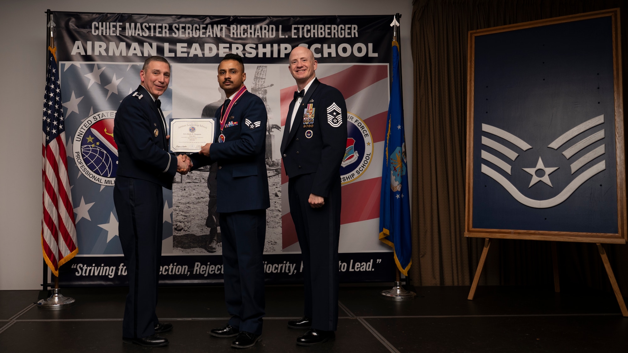 A photo of airmen posing with an award